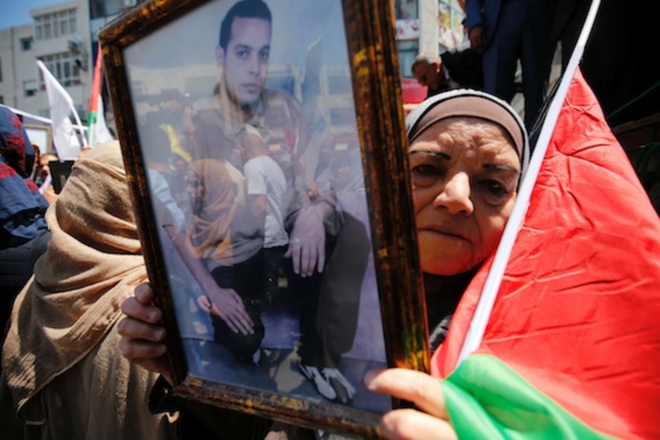 Una mujer palestina sostiene el retrato de su hijo preso. (Abbas MOMANI/AFP) 