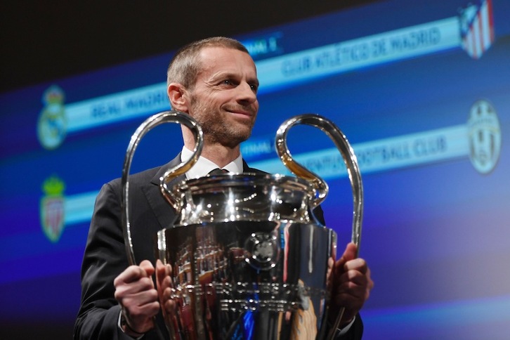 El presidente de la UEFA, Aleksander Ceferin, sostiene el trofeo de la Champions durante el sorteo. (Richard JUILLIART/AFP)