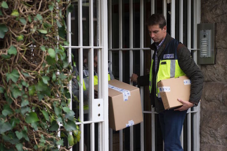 Agentes de la Policía española abandonan uno de los inmuebles registrados. (Josep LAGO / AFP)