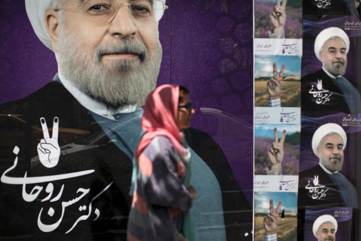 Una mujer pasa por delante de un cartel de Rohani. (Behrouz MEHRI/AFP)