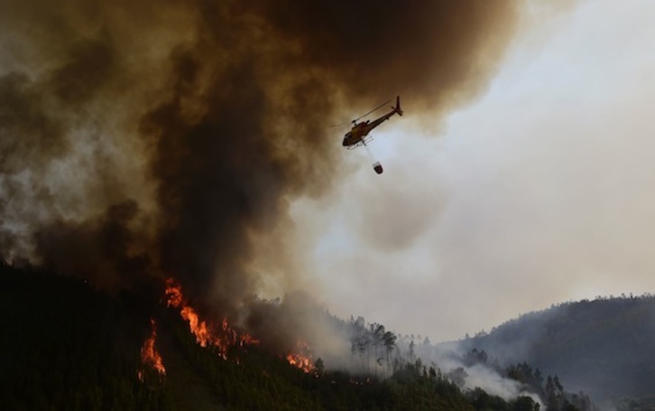 Un helicóptero trabaja en las labores de extinción del incendio. (Miguel RIOPA/AFP)