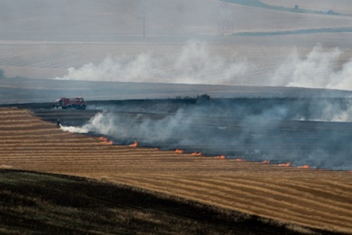 Los bomberos se esfuerzan para apagar el incendio desatado en un campo cosechado de Esparza de Galar. (Iñigo URIZ/ARGAZKI PRESS)