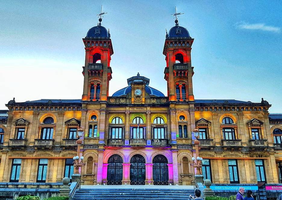 El Ayuntamiento de Donostia, iluminado con los colores del arco iris. (@EnekoGoia)