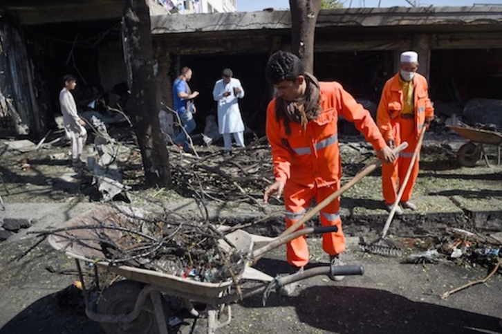 Trabajadores municipales de Kabul limpian el lugar donde se ha producido el atentado. (Wakil KOHSAR/AFP) 