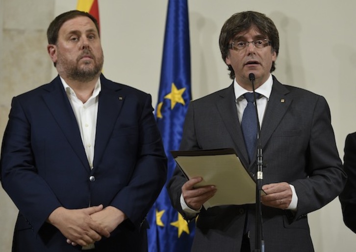 El vicepresident y conseller de Economía, Oriol Junqueras, junto al president, Carles Puigdemont. (Lluis GENÉ/AFP)