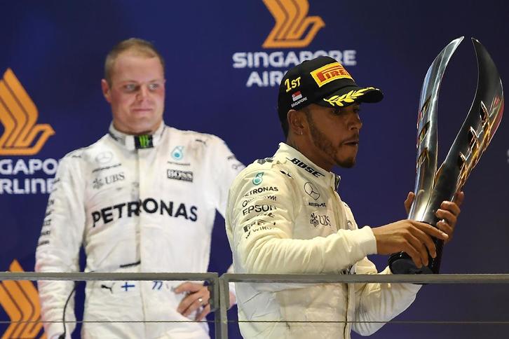Hamilton en el podio, con Bottas detrás. (Manan VATSYAYANA/AFP)