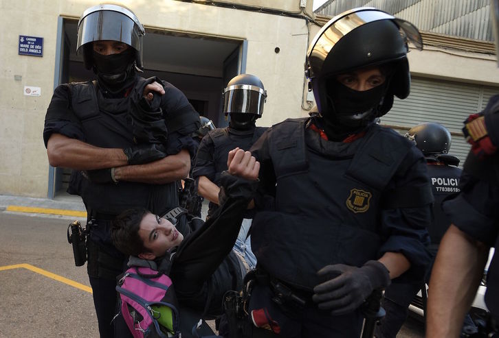 Los Mossos desalojan a una de las personas que protestaba frente a la oficina de Unipost. (Lluis GENE | AFP)