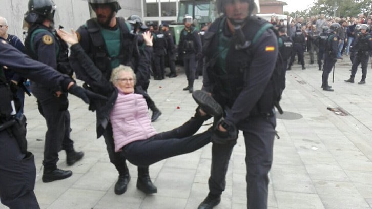 Guardia civiles llevan en volandas a una mujer mayor.