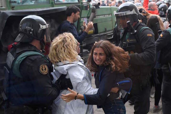 Guardias Civiles desalojan a dos mujeres. (Lluis GENE / AFP)