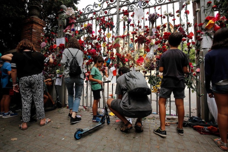 Flores en la verja del instituto Ramon Llull. (Josep LAGO/AFP)