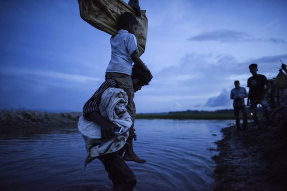 Un rohinyá cruza el río con su hijo sobre los hombros. (Fred DUFOUR/AFP)