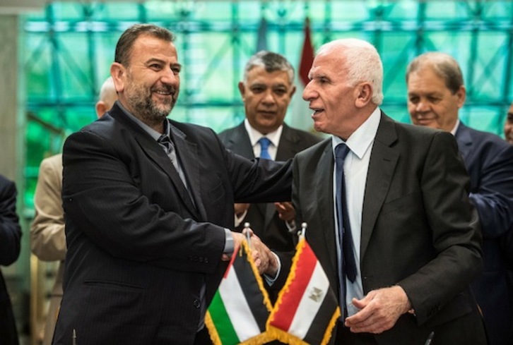 Saleh al-Aruri (Hamas) y Azam al-Ahmad (Al-Fatah) estrechan sus manos tras firmar el acuerdo de reconciliación en El Cairo. (Khaled DESOUKI/AFP)