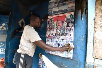Un hombre limpia un retrato de Sankara. (Sia KAMBOU/AFP)
