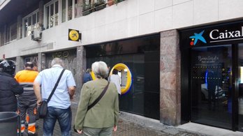 Sagrada Familia inguruko Caixabanken bulego batean jende ilarak goizeko lehen orduan.