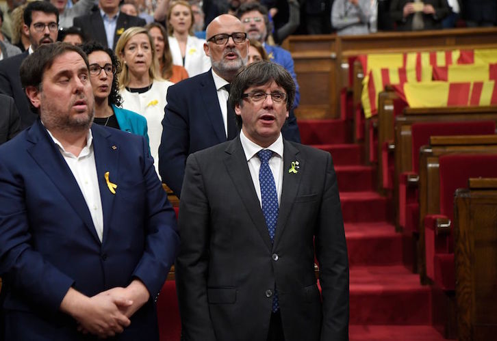 Junqueras y Puigdemont cantando ‘Els Segadors’ en el Parlament tras proclamarse la República. (AFP)