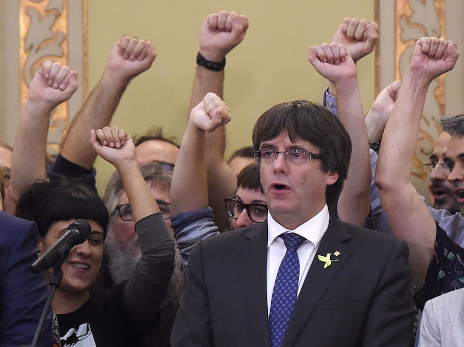 Puigdemont, con los miembros de la CUP a su espalda. (Josep LAGO / AFP)