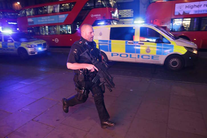Un policía armado corre por Oxford Street tras el «incidente». (Daniel LEAL-OLIVAS/AFP)