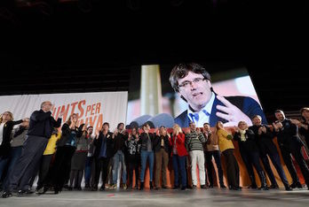 Puigdemont intervino por videoconferencia en la apertura de la campaña de Junts per Catalunya. (Lluís GENÉ/AFP)