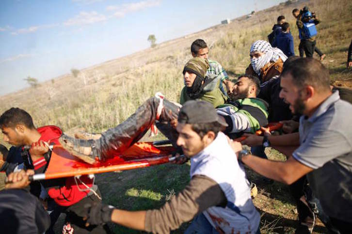Evacúan a uno de los palestinos heridos por disparos israelíes. (MOHAMMED ABED / AFP)