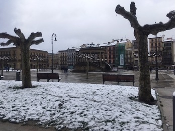 Una ligera capa de nieve cubre algunas zonas de la plaza del Castillo de Iruñea.