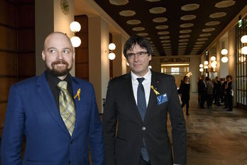 Puigdemont, junto a un parlamentario finlandés durante su visita a la Cámara del país. (Martti KAINULAINEN/AFP)