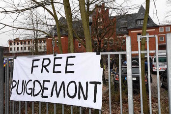 Pancarta por la libertad de Puigdemont ante el edificio en el que permanece retenido. (Patrik STOLLARZ / AFP)