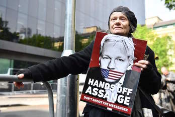 Una mujer sostiene a las puertas del tribunal un cartel de apoyo a Assange. (Daniel LEAL-OLIVAS/AFP)