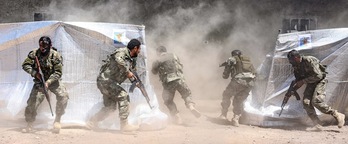 Rebeldes sirios apoyados por Turquía realizan ejercicios entre carpas con la bandera de las YPG. (Nazeer AL-KHATIB / AFP)