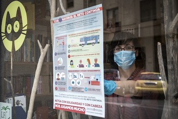 Colocación de uno de los carteles sobre el coronavirus en un comercio. (GOBIERNO DE NAFARROA)