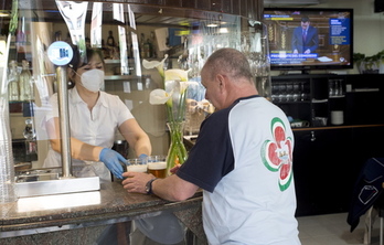 Una camarera atiende a un cliente en un bar de Iruñea con medidas para hacer frente al coronavirus. (Iñigo URIZ/FOKU)