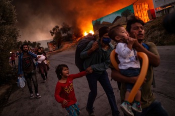 Refugiados huyen del fuego en el campo de Moria. (Angelos TZORTZINIS/AFP) 