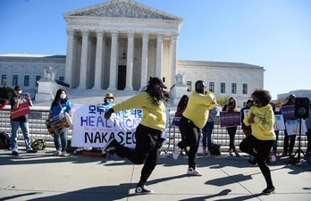 Manifestantes en favor del Obamacare bailan ante la sede del Supremo durante la audiencia. (Nicholas KAMM/AFP)