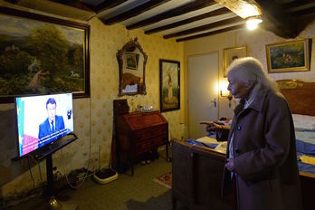 Una anciana de 93 años escucha el discurso de fin de año de Macron. (Jean Francois MONIER | AFP)