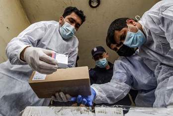 Personal sanitario con algunas de las vacunas que han llegado a Gaza. (Said KHATIB/AFP)