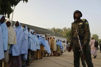 Un soldado junto a las niñas secuestradas la semana pasada en una escuela comunitaria en Jangebe. (AFP)