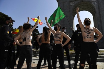 Activistas de Femen rodeadas por policías e increpadas por los franquistas en Madrid. (Philippe MARCOU/AFP)
