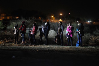 Un grupo de migrantes, en Texas, alumbrados por las patrullas fronterizas. (Joe RAEDLE / AFP)