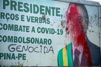 Una valla publicitaria con la imagen del presidente de Brasil, Jair Bolsonaro, manchada con pintura y heces como protesta por su gestión de la pandemia, en la localidad de Carpina, Pernambuco. (Leo Malafaia | AFP)