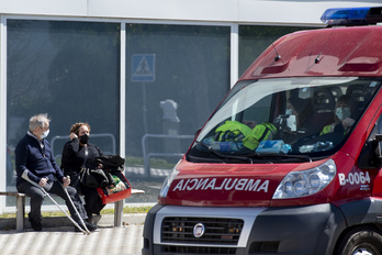 Dos personas observan el paso de una ambulancia en Iruñea.      (Iñigo URIZ I FOKU)