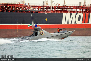 Imagen de archivo de la televisión iraní IRIB de una patrullera iraní junto a un carguero. (AFP)