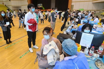 Estudiantes vacunándose contra el covid-19 en una universidad de Wuhan. (AFP)