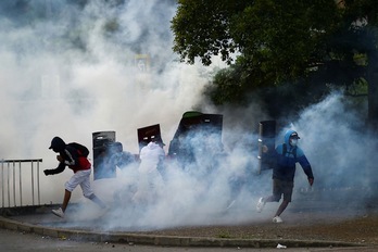 El gas lacrimógeno lanzado por la Policía se expande en torno a los manifestantes durante una protesta contra el Gobierno de Iván Duque, en Cali, el pasado 22 de mayo. (Luis ROBAYO | AFP)