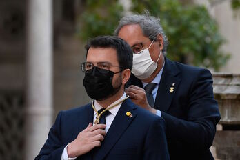 Aragonès recibe la medalla de mano de su antecesor, Quim Torra. (Josep LAGO/AFP)