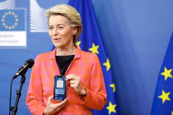 La presidenta de la Comisión Europea, Ursula von der Leyen, muestra su pasaporte covid, el martes en Bruselas. (Johanna GERON | AFP)