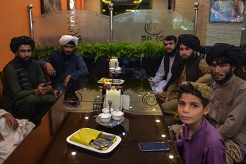 Talibanes posan mientras desayunan en Kabul. (Wakil KOHSAR-AFP)