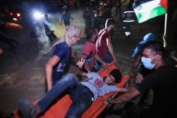 Palestinos trasladan a uno de los heridos. (Said KHATIB / AFP)