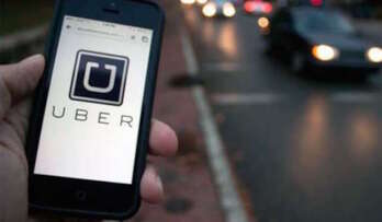 Una persona entra en la aplicación de Uber para pedir un coche con chófer. (AFP)