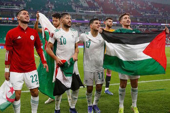 Jugadores de la selección argelina, con banderas palestinas, tras eliminar a Qatar.(Jack GUEZ/AFP)