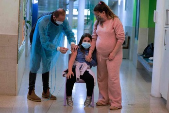 Una menor israelí recibe una dosis de la vacuna contra el covid. (Menahem KAHANA/AFP)