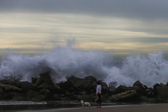 Un hombre toma fotografía las grandes olas en Venice Beach, una playa de Los Ángeles (California), el sábado.